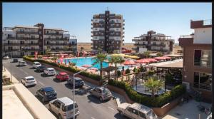 a view of a parking lot with cars and a pool at Kıbrısın gözdesi Long Beach de Havuz manzaralı stüdyo daire in Trikomo