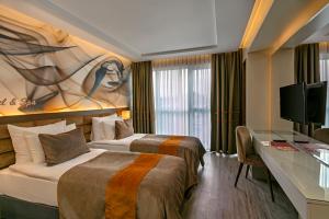 ein Hotelzimmer mit zwei Betten und einem Schreibtisch in der Unterkunft B Business Hotel & Spa in Antalya