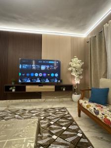 a living room with a large flat screen tv at Luxury Stay in Cairo in Sheikh Zayed