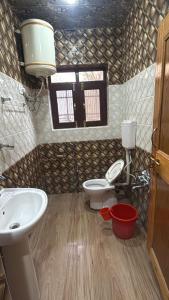 a bathroom with two toilets and a sink and a window at Himalayan Stay in Sonāmarg