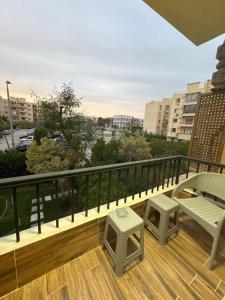a balcony with a bench and a table and stool at Luxury Stay in Cairo in Sheikh Zayed