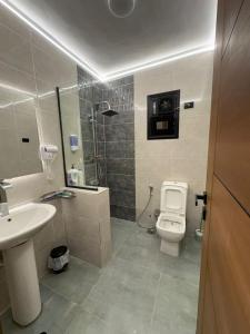 a bathroom with a toilet and a sink and a shower at Luxury Stay in Cairo in Sheikh Zayed +5 photos