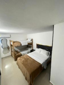 a bedroom with two beds and a bunk bed at ARY Hotel in Valledupar +8 photos