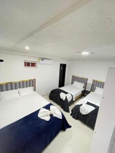 a room with two beds and two chairs at ARY Hotel in Valledupar