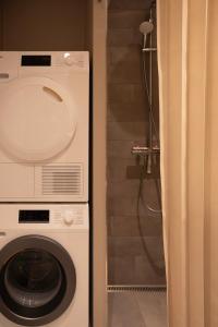 a washing machine in a bathroom with a shower at Designer apartment with city view in Copenhagen