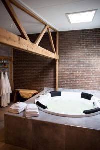 a large bath tub in a room with a brick wall at Hut 16 Bed, stad & privé wellness in Zutphen +39 photos