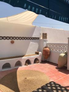 a patio with a table and chairs and an umbrella at El Baraka in Houmt Souk