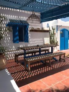 two wooden benches sitting in front of a building at El Baraka in Houmt Souk +10 photos