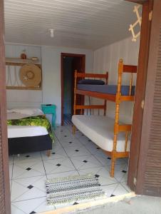 a room with two bunk beds and a doorway at Pousada Boguitos - Pé na areia na Iha do Mel! in Paranaguá +14 photos