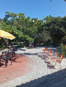 a group of chairs and tables on a sandy beach at Pousada Boguitos - Pé na areia na Iha do Mel! in Paranaguá