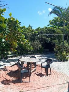 two chairs and a table and a table and chairs at Pousada Boguitos - Pé na areia na Iha do Mel! in Paranaguá