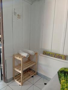 a bathroom with a shower with a wooden shelf at Pousada Boguitos - Pé na areia na Iha do Mel! in Paranaguá