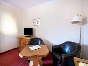 a room with two chairs and a table and a tv at Geräumiges Studio in Bad Birnbach in Bad Birnbach