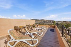 a row of chairs on a balcony with a view at Surf Appart Morocco in Tamraght Ouzdar