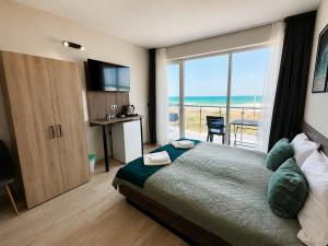 a bedroom with a bed and a view of the ocean at Paradise View Rooms in Shkorpilovtsi