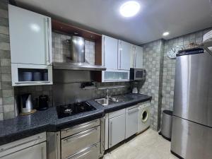a kitchen with white cabinets and a stainless steel refrigerator at Stars Hostel Tangier in Tangier