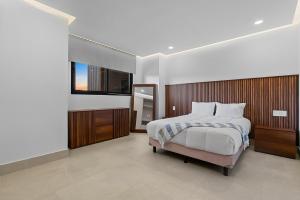 a bedroom with a large bed and a television at PANAREA - Luxury Beachfront Condos in Bucerias in Bucerías +91 photos