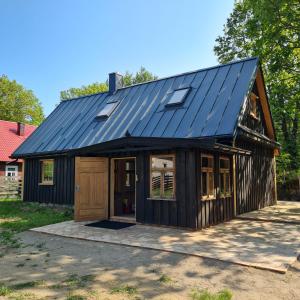 a house with a metal roof and a garage at Siedlisko Leśny Jaśmin in Łuka