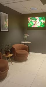 a waiting room with a chair and a flat screen tv at Hotel Expo Stockholm in Stockholm