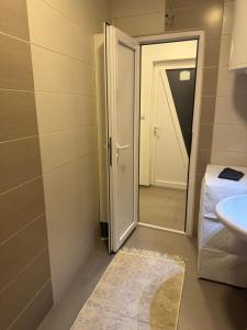 a bathroom with a toilet and a sink and a door at Studio Maša in Zaječar +3 photos