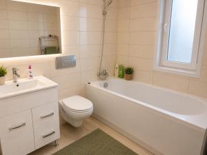 a bathroom with a tub and a toilet and a sink at Green Deluxe Apartment Cosmopolis in Ştefăneştii de Jos