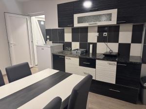 a kitchen with black and white tile on the wall at Studio Maša in Zaječar