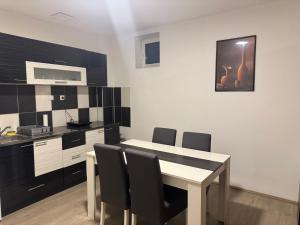 a kitchen with a table and black and white at Studio Maša in Zaječar