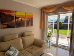 ein Wohnzimmer mit Sofa und Glasschiebetür in der Unterkunft Ferienwohnung Balkon oder Terrasse in Kall