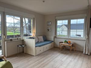a living room with a blue couch and windows at Seeblick Apartments Mühlau in Mühlau
