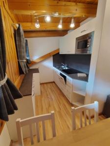 a kitchen with a table and chairs and a microwave at La Pineta Apartment in Padola