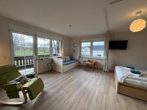 a large room with a bed and a couch and windows at Seeblick Apartments Mühlau in Mühlau