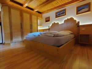 a bedroom with a wooden bed in a room at La Pineta Apartment in Padola