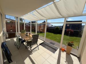 eine überdachte Veranda mit Tisch und Stühlen in der Unterkunft Ferienwohnung Balkon oder Terrasse in Kall