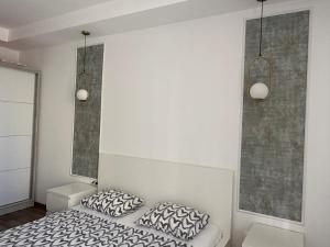 a bedroom with a bed and two pillows on it at Green Deluxe Apartment Cosmopolis in Ştefăneştii de Jos +6 photos