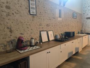 a kitchen with white cabinets and a counter top at Studio 80m2 a la ferme tout confort in Courdemanche +8 photos