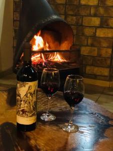 two glasses of red wine next to a fireplace at Pousada requinte serrano in Urubici
