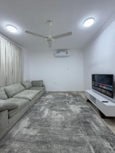 a living room with a couch and a tv at جوهرة الخوض in Al Khawḑ +5 photos