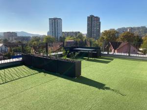 a tennis court with a table on a tennis court at Apartment Vila Idila in Tuzla