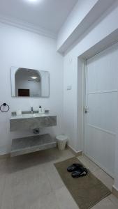 a bathroom with a sink and a toilet and a mirror at جوهرة الخوض in Al Khawḑ