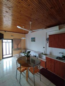 a kitchen with a table and a dining room at Takis Haikos House two minutes walk to the beach Peroulia in Vounaria +44 photos