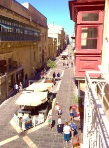 un grupo de personas caminando por una calle con sombrillas en Luciano Valletta Boutique en La Valeta