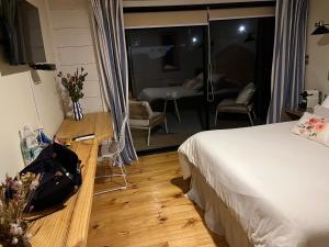 a bedroom with a bed and a view of a living room at Hotel & Boulevard Pacífico in Matanzas