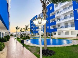 a street light in front of a building with a pool at Spacious Family Apartment - Air Conditioning, Pool & Garden Views in Martil