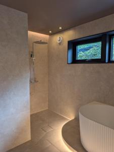 a bathroom with a shower with a tub and a window at Reed Panorama in Reed