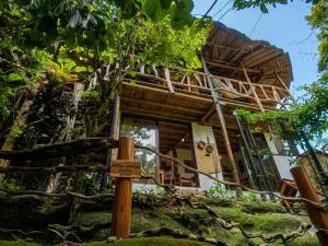 a wooden sign in front of a house at Sierra Tayrona hostel in El Zaino