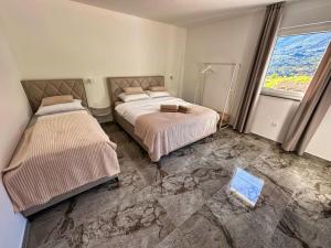 a bedroom with two beds and a marble floor at Apartmani Jozić 2 in Ripci