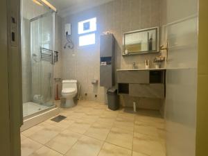 a bathroom with a toilet and a shower and a sink at دار ناصر in Riyadh +45 photos
