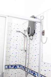 a shower in a bathroom with blue and white tiles at Apartment in Ancon in Ancón