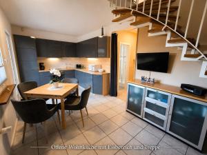 a kitchen and dining room with a table and a staircase at Ostseeferienhaus Usedom Lütow am Achterwasser Hundefreundlich Naturlage Familie Christian Ziethen in Lütow