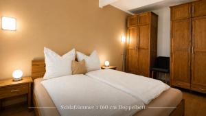 a bedroom with a bed with white sheets and pillows at Ostseeferienhaus Usedom Lütow am Achterwasser Hundefreundlich Naturlage Familie Christian Ziethen in Lütow +14 photos